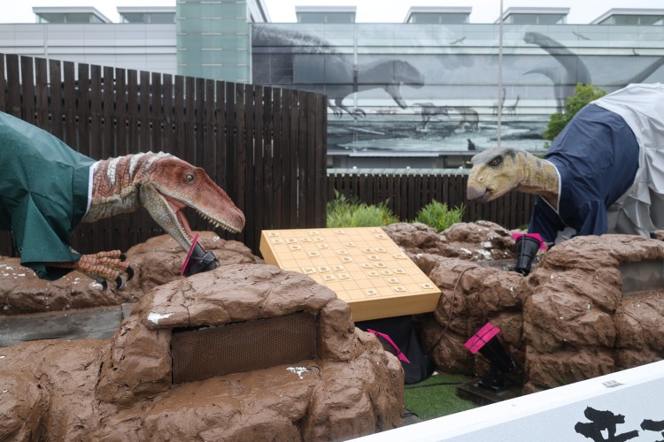 将棋に向かうフクイラプトルとフクイサウルスのロボット